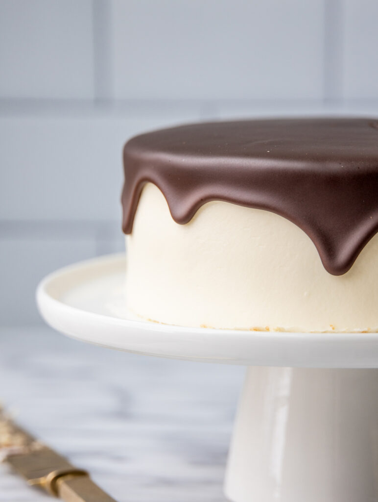 boston cream pie on a white cake stand